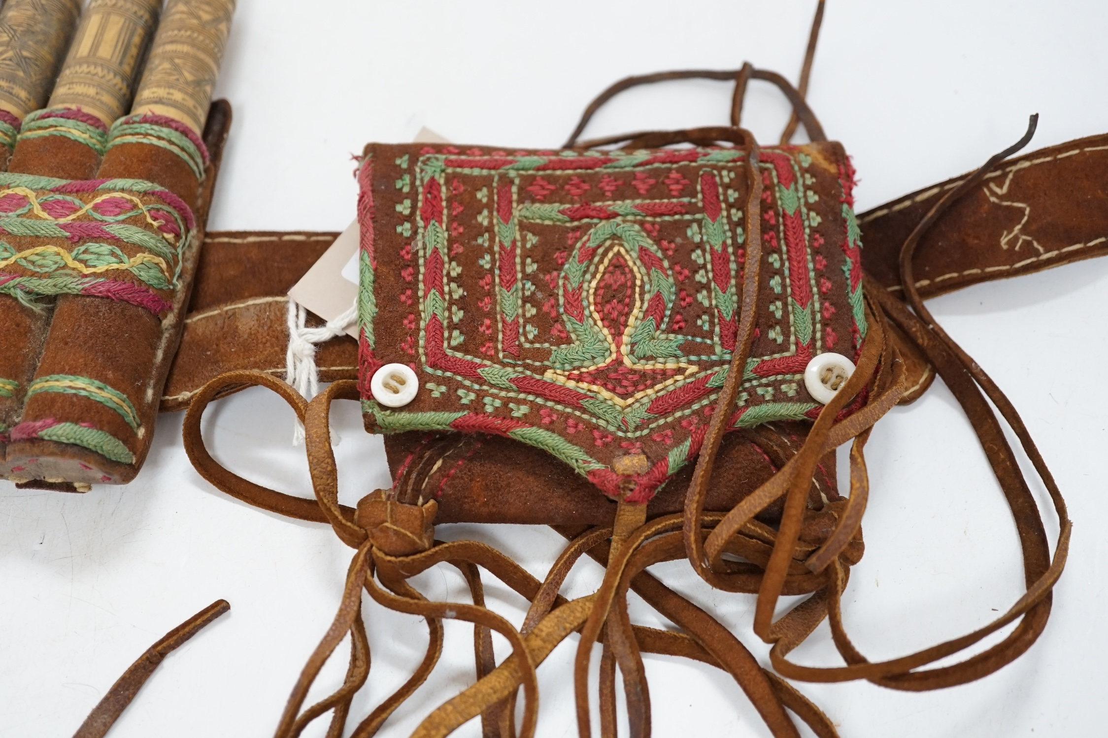 A 19th century Armenian gazyr belt, with decorative silk embroidery on suede and carved bamboo shot and gunpowder containers, 68cm long. Condition - slightly worn from use